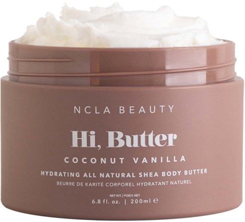 Ein runder rosa Topf mit 'Hi, Butter' Beschriftung enthält Shea-Body-Butter mit Kokos-Vanille-Duft, oben weiße Creme.