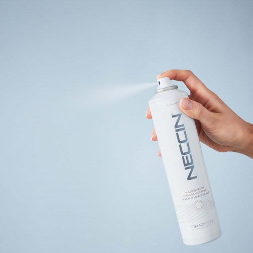 A hand sprays a white can labeled 'NEOCIN' against a light background.