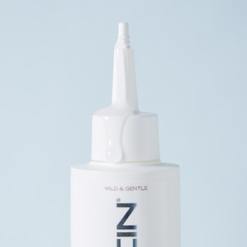 En vit flaska med en lång, smal pip, märkt "MILD & GENTLE Z," mot en ljus bakgrund.