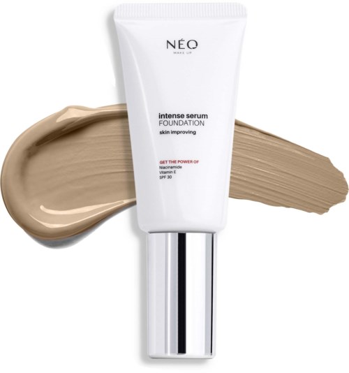 Een witte tube foundation met zilveren deksel, toont beige make-up op de achtergrond, gemarkeerd 'NEO' met huidverzorgingsinformatie en SPF 30.
