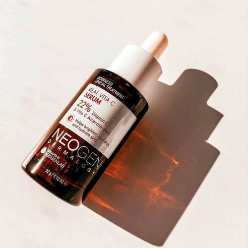Een flesje serum met pipet, gemarkeerd voor huidverzorging met vitamine C, op een lichte achtergrond.