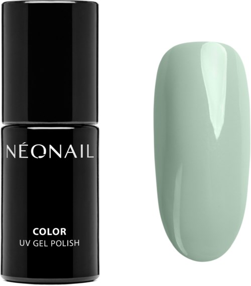 A black bottle of nail polish next to a long, light green painted nail tip.