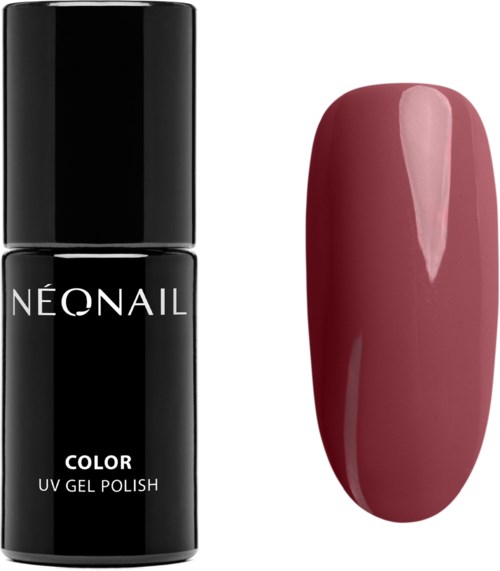 Black nail polish bottle and a long pinkish-red painted nail.