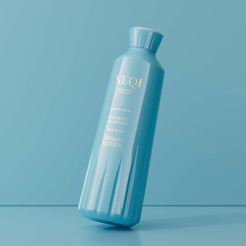 Een blauwe shampoo fles met gouden tekst, schuin en staand op een oppervlakte tegen een blauwe achtergrond.