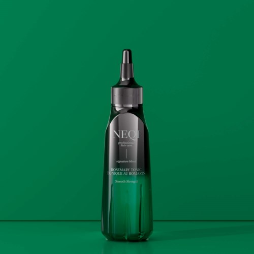 Een groene fles met een zwart sproeikopje, genaamd NEQI rozemarijn tonic, staat tegen een groene achtergrond.