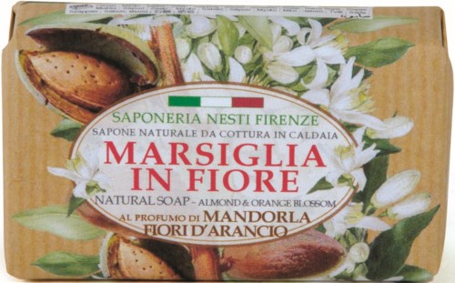 A soap with almonds and orange blossom scent, decorated with flowers and a split almond. Text in Italian and English.