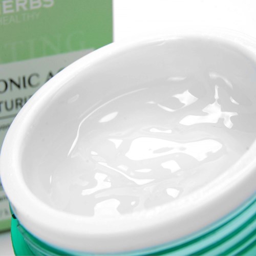 A green and white container with clear gel or cream inside, possibly for skincare or haircare use.