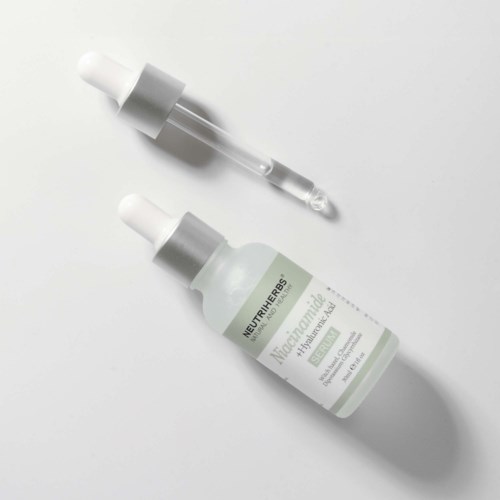Eine Flasche mit Tropfenzähler und 'Neutriherbs'-Beschriftung sowie eine Glasanzeige auf weißer Oberfläche.