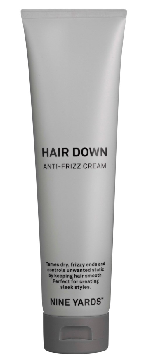 Szara tubka z napisem 'Hair Down Anti-Frizz Cream' od Nine Yards, służy do ujarzmiania puszenia i wygładzania włosów.