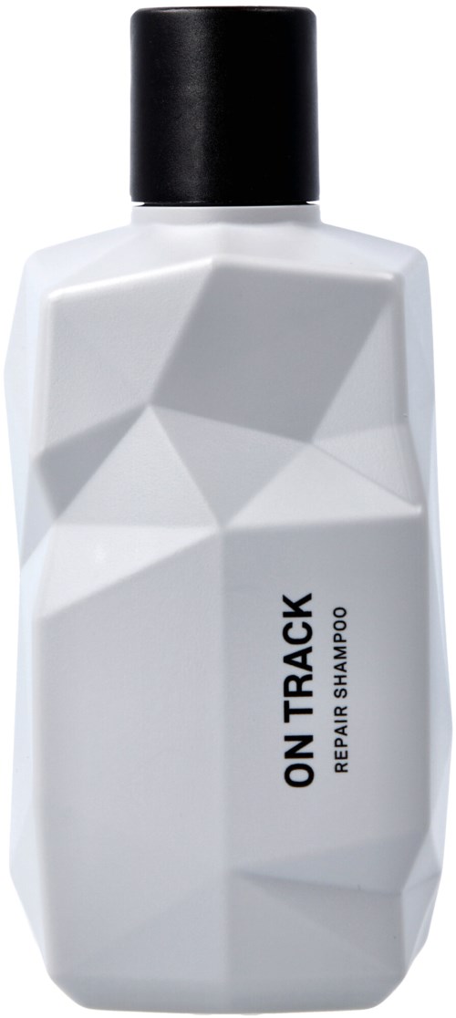 Biała butelka szamponu z czarną nakrętką, oznakowana 'ON TRACK REPAIR HAIR SHAMPOO'.