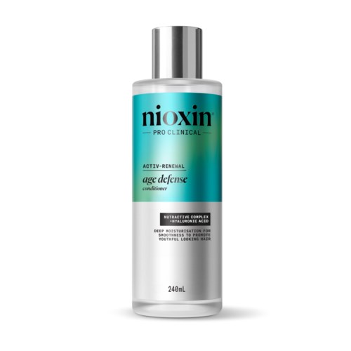 Een fles Nioxin Pro Clinical Age Defense conditioner met een zilveren dop en teal, wit en zwart label.