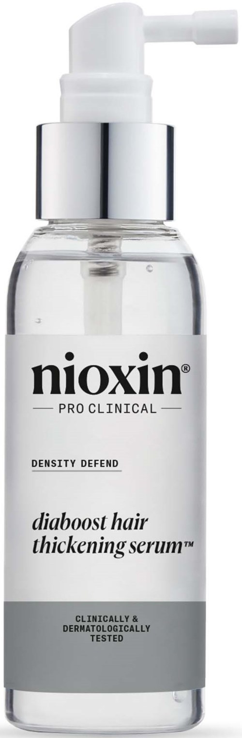 Een doorzichtige fles met pomp, label Nioxin Pro Clinical voor haarverdikking, met zilveren en zwarte tekst.