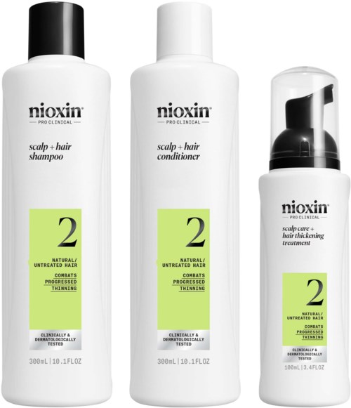 Drie witte flessen van Nioxin haarproducten met groene labels; shampoo, conditioner en behandeling voor dunner wordend haar.