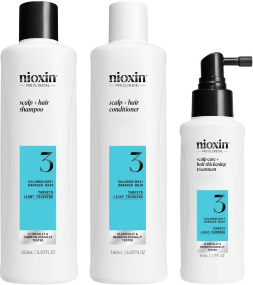 Drie witte haarverzorgingsflessen met labels voor hoofdhuid en haarbehandelingen, met blauwe en zwarte tekst en doppen, verschillende maten.