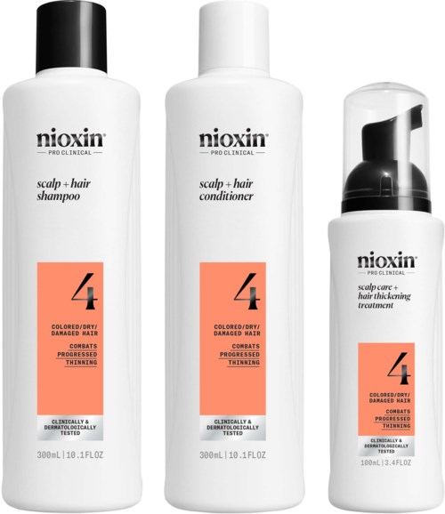 Drie flessen Nioxin haaproducten voor beschadigd haar, inclusief shampoo, conditioner en behandeling, met oranje labels.