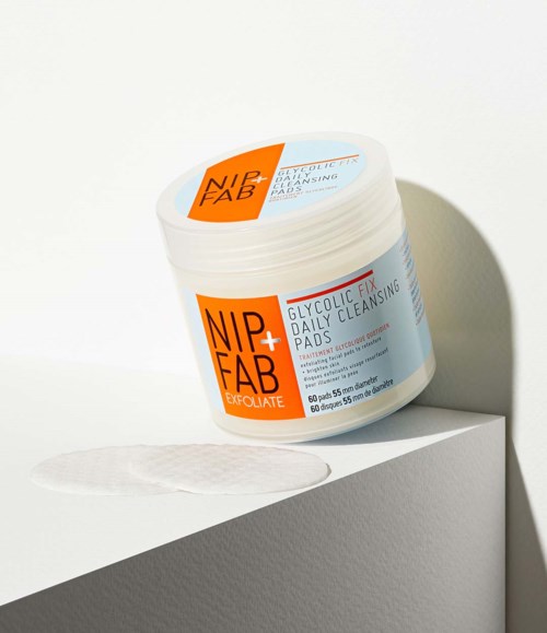 Een potje huidverzorgingspads gemarkeerd "NIP+FAB" en "Glycolic Fix Daily Cleansing Pads".