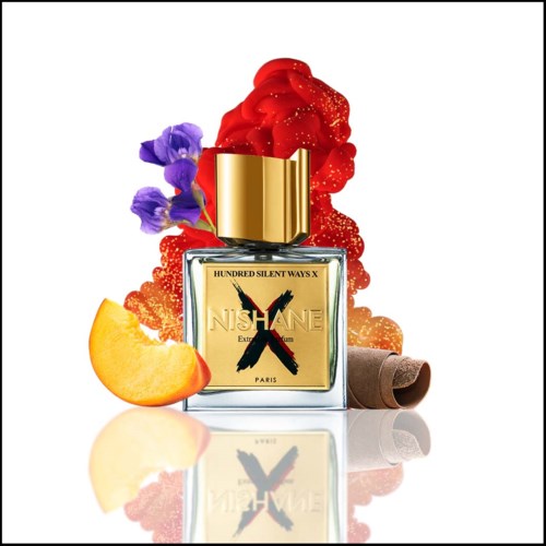 Ein Parfümflasche mit goldener Haube, umgeben von bunten Blumen, Fruchtscheiben und dekorativen Elementen.