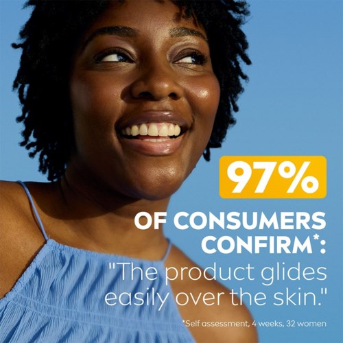 Smiling woman with natural hair and a blue top, promotional text about product satisfaction and skin glide.