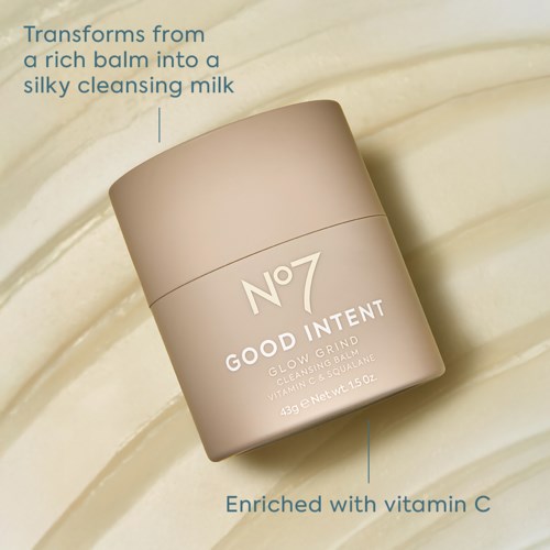 Een cosmeticapotje met label No 7 Good Intent Glow Grit met vitamine C, op een beige oppervlak.