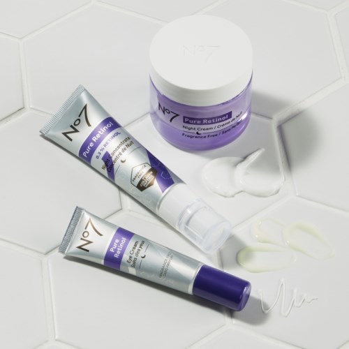 Zwei Tuben mit No7 Hautpflegecreme und ein Glas Nachtcreme sind auf einer weißen Fliesenoberfläche mit etwas Creme entfernt.