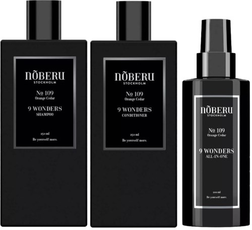 Drei schwarze Flaschen mit weißen Etiketten für Shampoo, Conditioner und All-in-One-Produkt von Nöberu Stockholm.