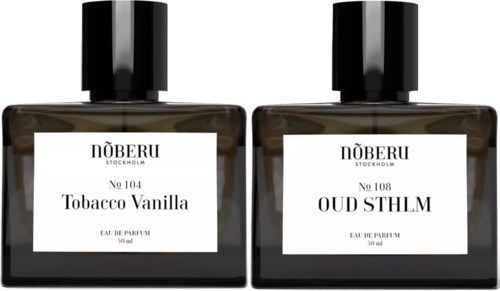 Two perfume bottles with black caps and white labels, named Tobacco Vanilla and Oud SLMH, 50 ml.