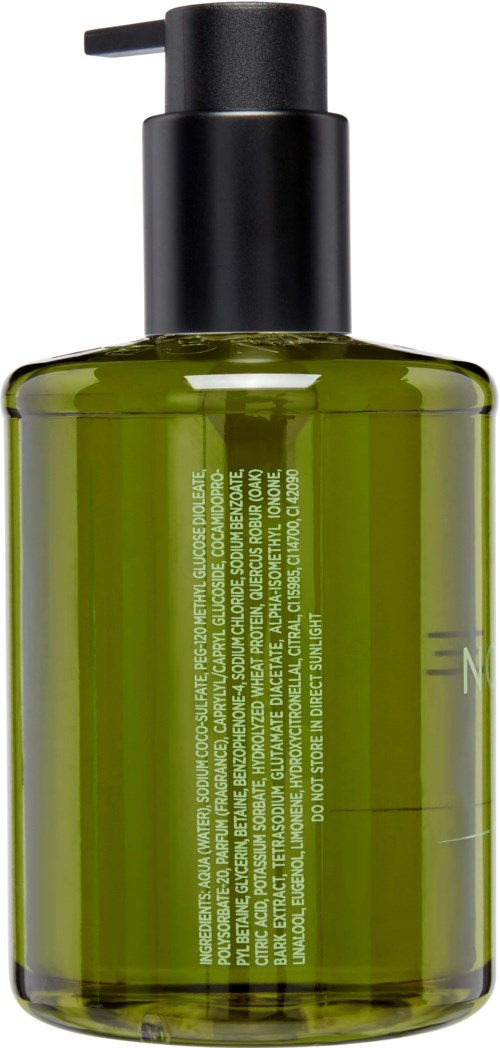 Grüne Flasche mit schwarzem Pumphahn, enthält Flüssigkeit, wahrscheinlich für Haut- oder Haarpflege, mit Text auf der Flasche.