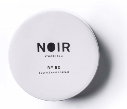 A round white container with black text, indicating a product called Noir Stockholm No 80 Souffle Paste Cream.