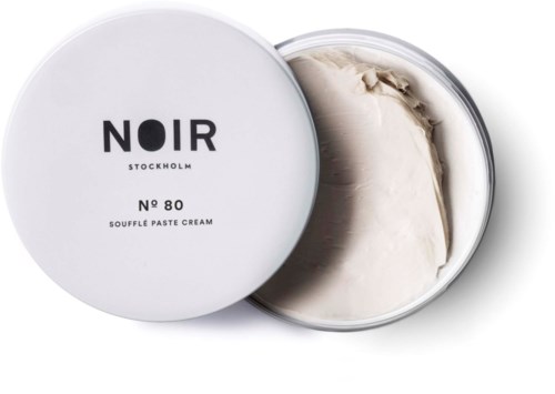 A white container of Noir Stockholm soufflé paste cream, with the lid partially open showing the creamy substance inside.