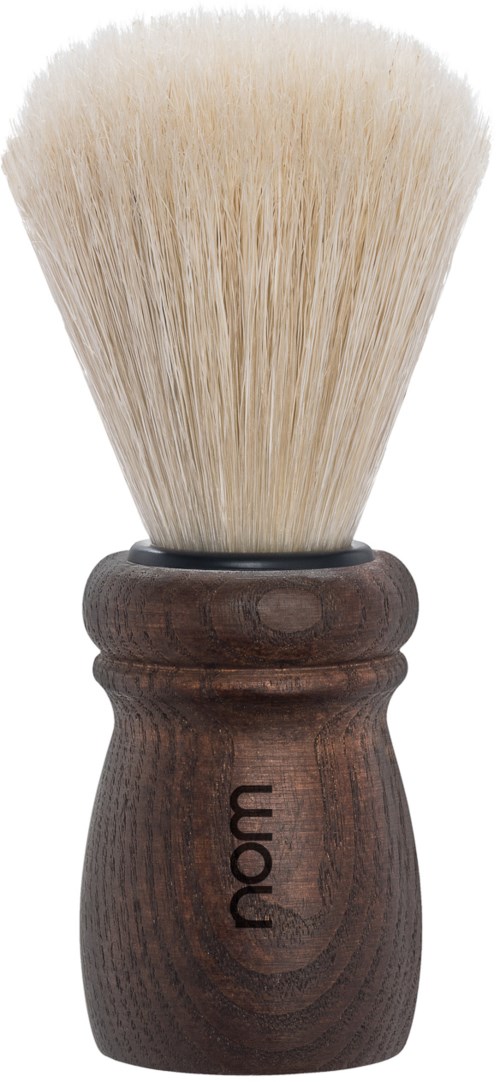 A shaving brush with white bristles and a wooden handle. The handle has the word 'nom' written on it.
