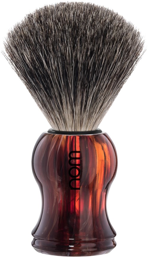 A shaving brush with a dark, curved handle and thick bristles. The handle has the word 'Omega' on it.