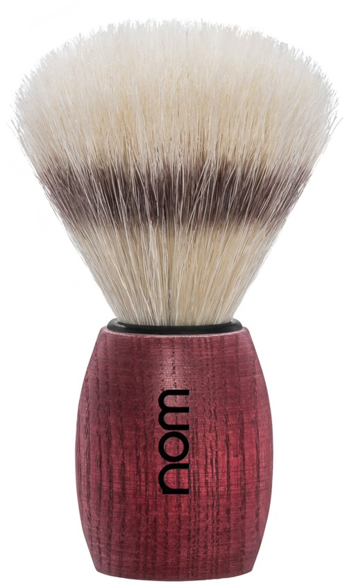 A shaving brush with cream-colored bristles and a red wooden handle with the word "nom" on it.