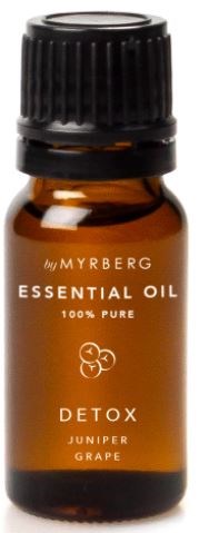 En liten bärnstensfärgad flaska med etikett "Essential Oil" och dofter "Detox" med juniper och druva.