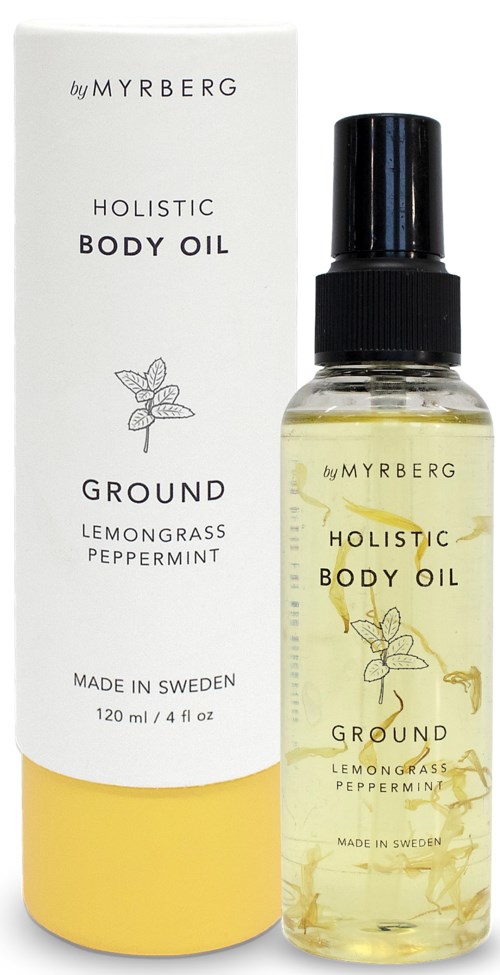 Eine transparente Sprühflasche mit gelber Flüssigkeit, begleitet von einer weißen Verpackung, beschriftet 'Holistic Body Oil' mit Zitrone, Gras und Pfefferminz.