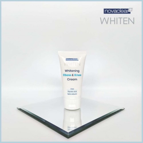 Eine weiße Tube mit der Aufschrift Novaclear WHITEN Elbow & Knee Cream steht auf einer reflektierenden schwarzen Oberfläche.