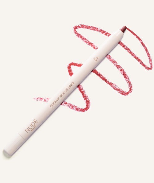 En vit makeup-penna märkt 'NUDE' ligger på papper med röda läppstiftsmärken.