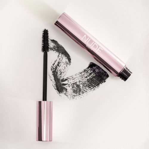A mascara wand with black mascara, and a pink tube labeled "NUDE". The mascara is spread on a white surface.