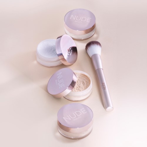 Vier containers met NUDE losse poeder, één open, en een make-up kwast op een lichte beige achtergrond.