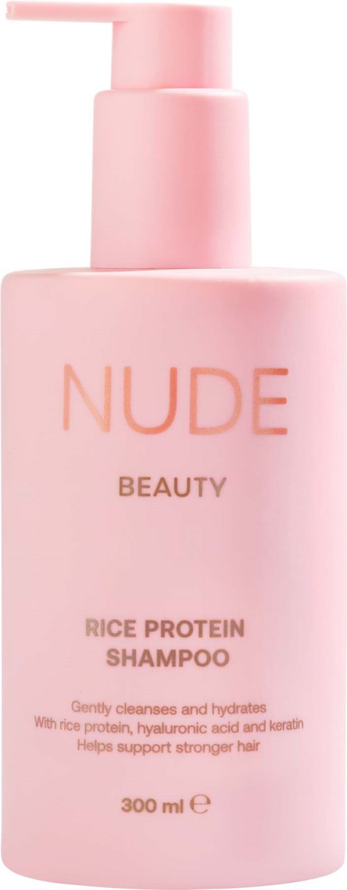 En rosa flaska med rice protein schampo med pump, märkt NUDE Beauty, hjälper till att rengöra och återfukta håret.