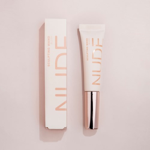 A tube and box of skincare product with minimalistic design and soft pink tones.