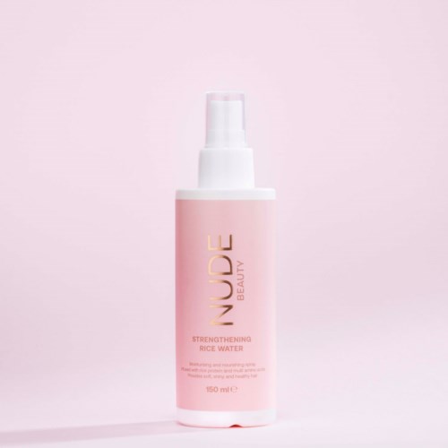 A pink bottle with a white pump, labeled 'LUDE Beauty Strengthening Rice Water' for skin care.