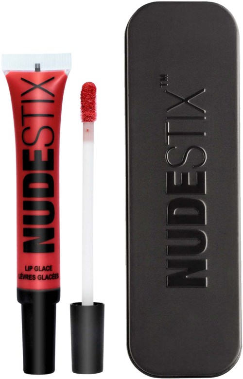A red lip gloss tube with a black cap and a wand, and a black metal case with the brand name NUDESTIX.