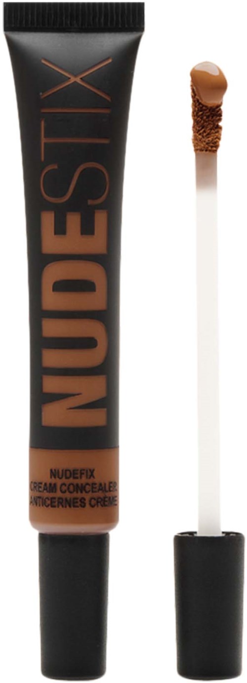 A concealer tube with the words "NUDESTIX" and a small applicator brush with brown product.