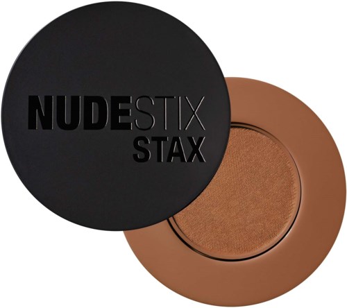 A round, brown compact with a black lid featuring bold text and a mirror inside. It appears to be makeup.
