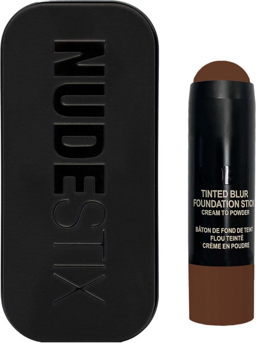 Een zwarte doos met 'NUDESTIX' erop en een bruine foundationstift.