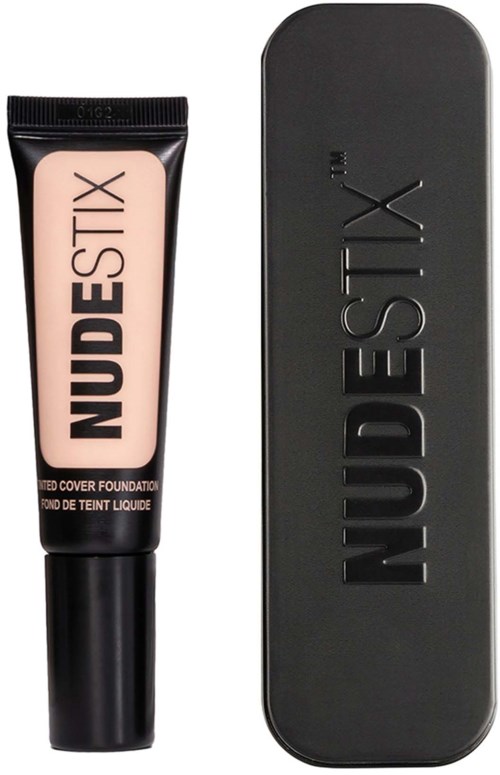Een tube foundation met NUDESTIX-merk en een zwarte rechthoekige doos ernaast.
