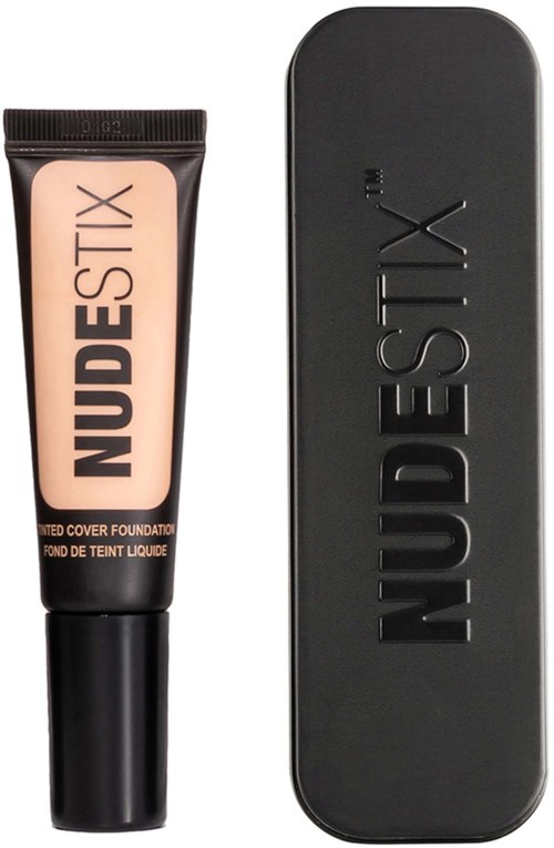 A tube of NudeStix foundation with a black cap and a black rectangular makeup case behind it.