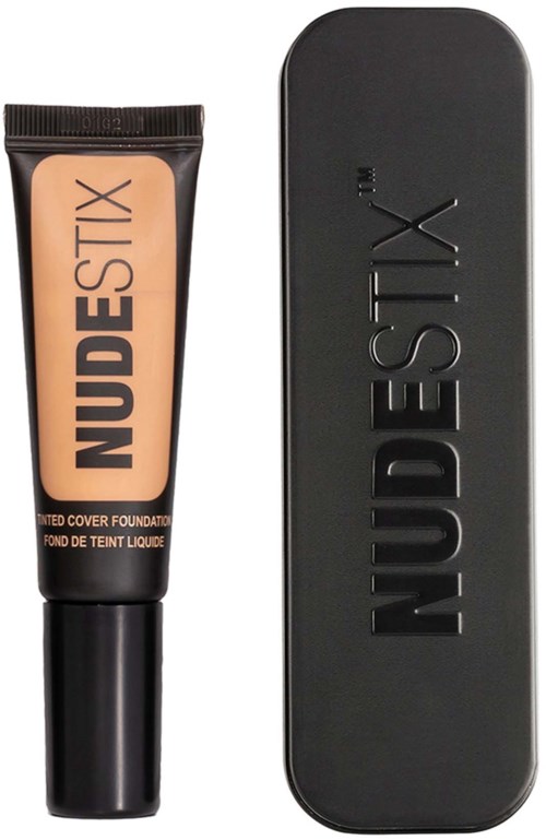 NudeStix foundationbuis en metalen doos worden getoond, beide zwart met merknamen embossed.