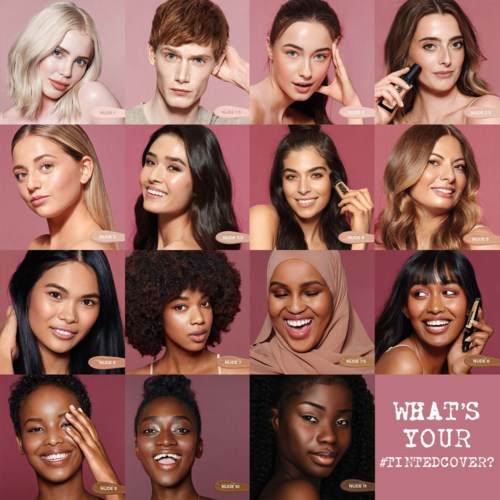Meerdere vrouwen met diverse huidskleuren en kapsels poseren tegen een roze achtergrond, promoten een make-up of schoonheidsmerk.