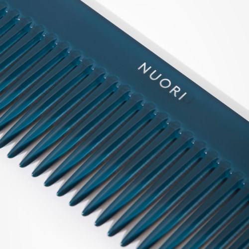 Eine blaue Bürste mit gleichmäßig verteilten Zähnen und dem Markennamen NUORI oben.